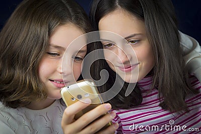 Portrait of two cute sisters looking at cell phone Stock Photo