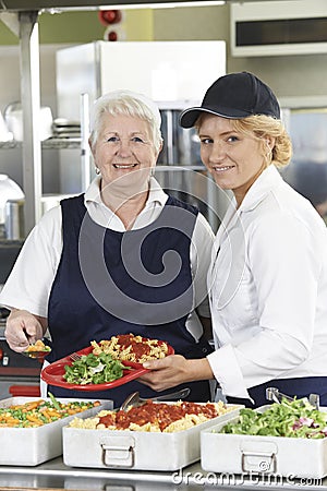 Portrait Of Two Dinner Ladies In School Cafeteria Stock Photo