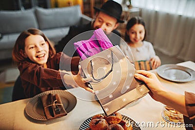 Jewish Family Sharing Gifts at Dinner Table Stock Photo