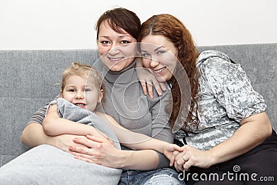 Portrait of two happy adults and little child Stock Photo