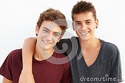 Portrait Of Two Hispanic Teenage Boys Leaning Against Wall Stock Photo