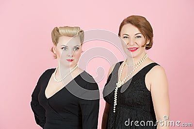 Portrait of ladies in black dress in american style on pink background. Stock Photo