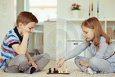 Portrait of two little children concentrated playing chess Stock Photo