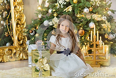 Portrait of two one young girls sisters close to white green Christmas tree. The girls in beautiful evening dresses clothes in New Stock Photo