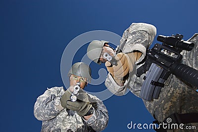 Portrait of two soldiers aiming with pistols Stock Photo