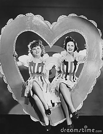 Portrait of two women sitting in large heart Stock Photo