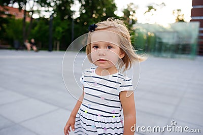 Portrait of a two year old girl in a striped dress. Stock Photo