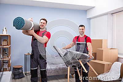 Portrait Of Two Young Male Movers Loading The Products Stock Photo