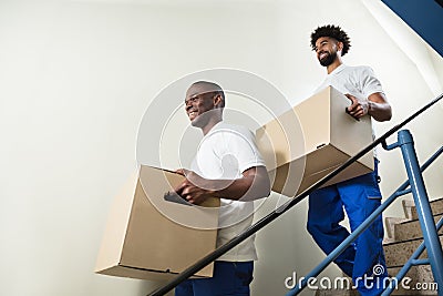 Portrait Of Two Movers Holding Cardboard Boxes Stock Photo