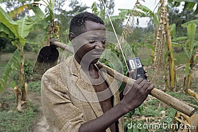 Portrait Ugandan farmer with hoe, portable radio Editorial Stock Photo