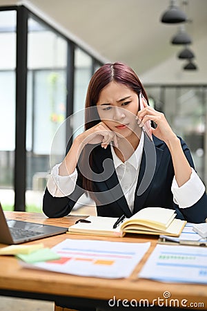 Portrait of an unhappy female boss unsatisfied with the business deal on the phone call Stock Photo