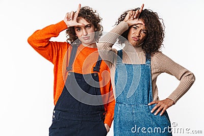 Portrait of unhappy multinational women pointing fingers upward Stock Photo