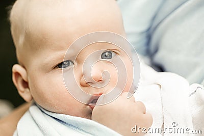 Portrait of a unique blue-eyed baby boy in teething pain Stock Photo