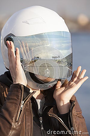 Portrait of unrecognizable European female motorcyclist with road reflection in her mirrored tinted visor of a helmet, collage Stock Photo