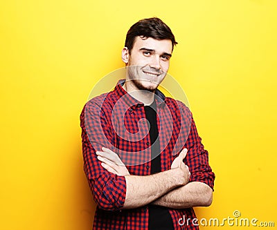 Portrait of unshaven young man wearing plaid shirt posing on camera with crossed arms hands Stock Photo