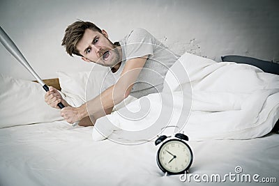 Portrait upset angry with baseball hit young man screaming at alarm clock Stock Photo