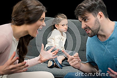 Portrait of upset daughter and arguing parents on black Stock Photo