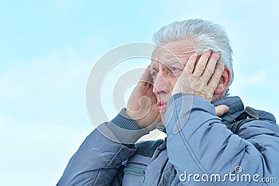 Portrait of upset senior man with headache Stock Photo