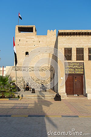 Portrait view of entrance of the Ras al Khaimah Museum in the morning sun with flags blowing Editorial Stock Photo