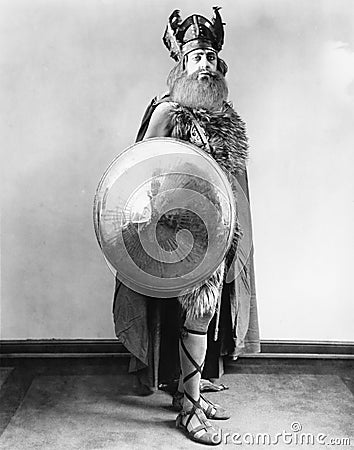 Portrait of a Viking warrior standing and holding a shield Stock Photo