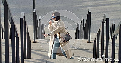 Portrait von fröhlicher, erwachsener Kaukasierin in Sonnenbrille und beigefarbenem Cottanz und Gesang auf der Stadtstraße Brunett stock video footage Portrait von fröhlicher, erwachsener Kaukasierin in Sonnenbrille und beigefarbenem Cottanz und Gesang auf der Stadtstraße Brunett stock video footage