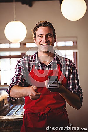 Portrait of waiter showing credit card machine Stock Photo