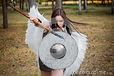 Portrait of a warrior woman in chain mail with steel bracers and wings behind her back. Stock Photo