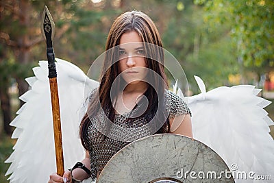 Portrait of a warrior woman in chain mail with steel bracers and wings behind her back. Stock Photo