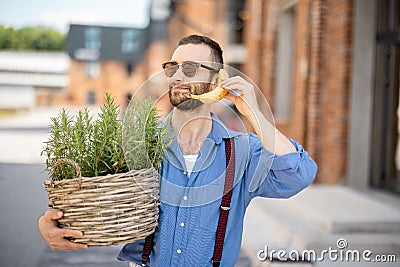 Portrait of weird stylish businessman with banana outdoors Stock Photo
