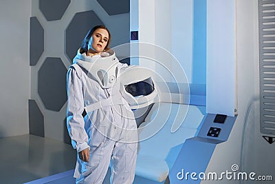 Portrait of a woman astronaut in a space suit, dreamy look up. Futuristic astronaut on Board the spacecraft. Stock Photo