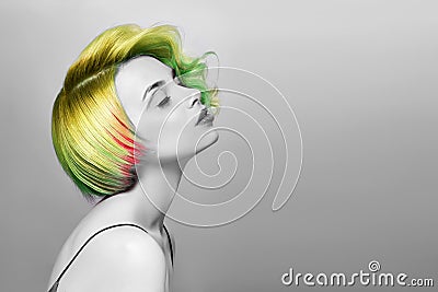 Portrait of a woman with bright colored flying hair, all shades of green. Hair coloring beautiful lips and makeup. Hair fluttering Stock Photo