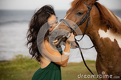 Portrait of woman and brown horse. Asian woman kissing horse. Romantic concept. Human animals relationship. Nature concept. Bali Stock Photo