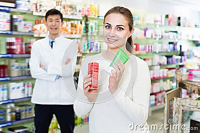 Portrait of woman client who is satisfied of recommended medicines in pharmacy. Stock Photo