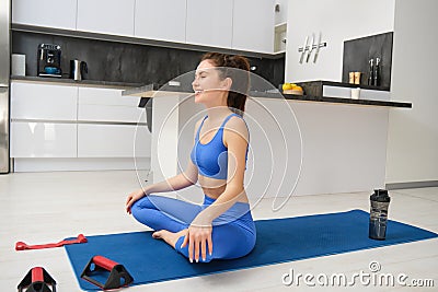 Portrait of woman concentrating on yoga breathing practice, does exercises, sits on rubber mat and meditating, workout Stock Photo