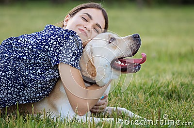 Portrait of a woman with her beautiful dog lying outdoors Stock Photo