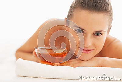 Portrait of woman laying on massage table with plate of honey Stock Photo
