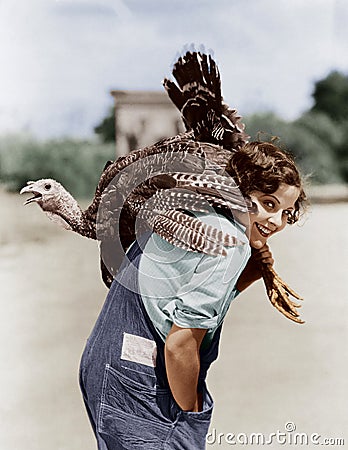 Portrait of woman with live turkey slung over shoulder Stock Photo