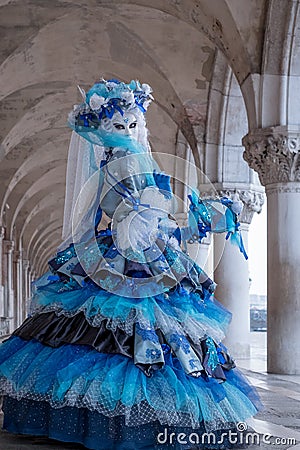 Portrait of woman looking back over her shoulder, under the arches at the Doges Palace, Venice, Italy during the carnival Editorial Stock Photo