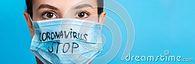 Portrait of a woman in medical mask with stop text at blue background. concept. Respiratory protection Stock Photo