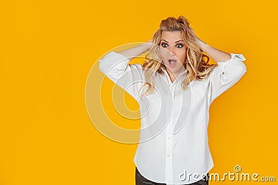 Woman in a panic with her hands clutching her head Stock Photo