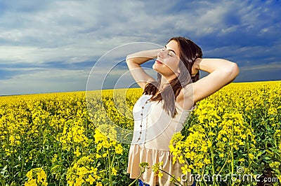 Portrait of woman relaxing in yellow colored field Stock Photo