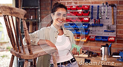 Portrait Of Woman Running Business In Workshop At Home Restoring And Upcycling Furniture Stock Photo