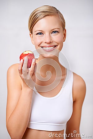 Portrait, woman and smile in studio with apple, nutrition and diet for health and wellness. Female person, fruit and Stock Photo