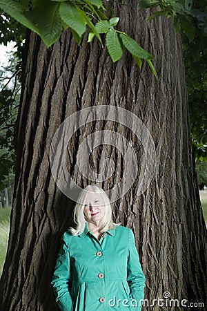 Portrait Of Woman Standing Beneath Tree Stock Photo