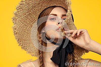 Portrait woman in straw hat on yellow background cropped view of summer dress model pigtails romance Stock Photo