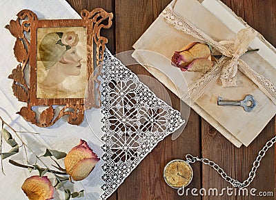 Portrait of a woman wearing a hat in an openwork frame, dried roses and a pile of letters. Retro composition Stock Photo