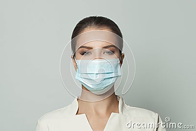 Portrait of woman wearing protective medical face mask on white background. Medicine, cosmetology and vaccination concept Stock Photo