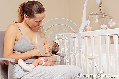 Mother breastfeed newborn infant baby sitting on the chair Stock Photo