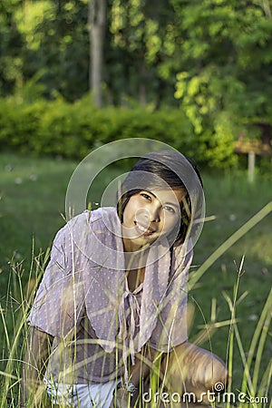 Portrait of Women with short hair brown skin Sitting on the grass Stock Photo