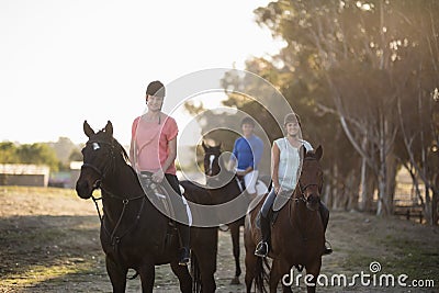 Portrait of women with trainer riding horse Stock Photo